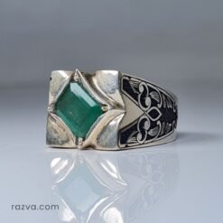 Bague chevalière masculine en argent avec pierre précieuse verte et motifs distinctifs.