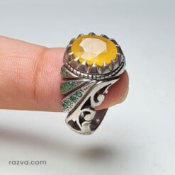 Bague artisanale pour homme en rubis jaune entourée d’émeraudes et monture détaillée.