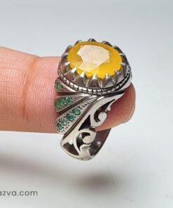 Bague artisanale pour homme en rubis jaune entourée d’émeraudes et monture détaillée.