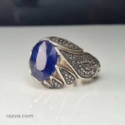 Bague artisanale en argent pour homme avec saphir bleu et motifs floraux détaillés.