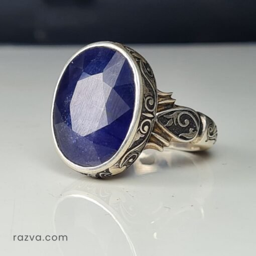 Bague artisanale pour homme en saphir bleu avec une monture gravée élégante.