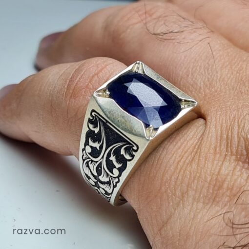 Chevalière artisanale homme en argent avec saphir bleu naturel et monture gravée.